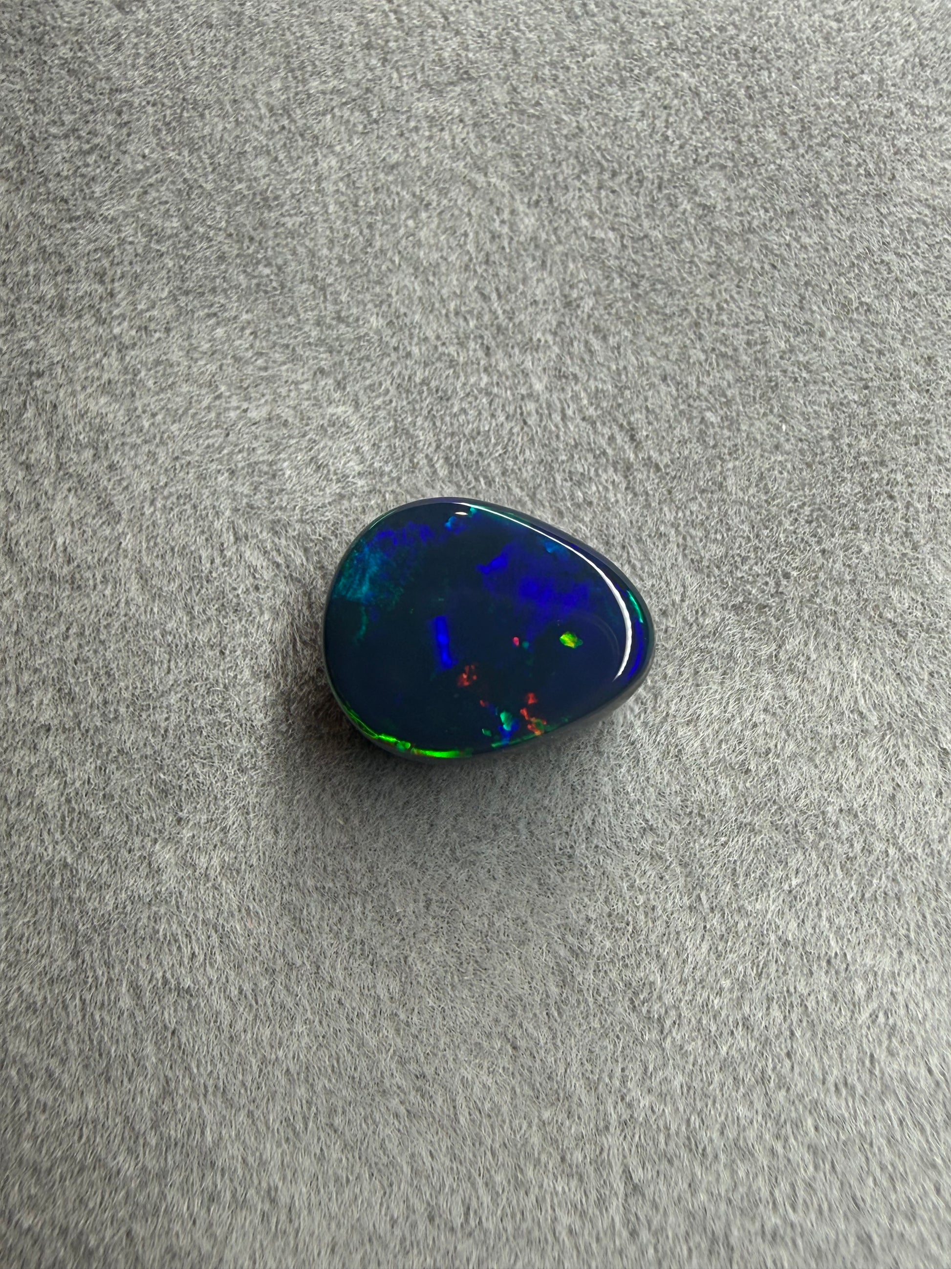 2 ct Lightning Ridge Black Opal in Tropfenform – australischer Edelopal mit leuchtendem Farbspiel in Blau, Grün, Gelb, Orange und Rot.