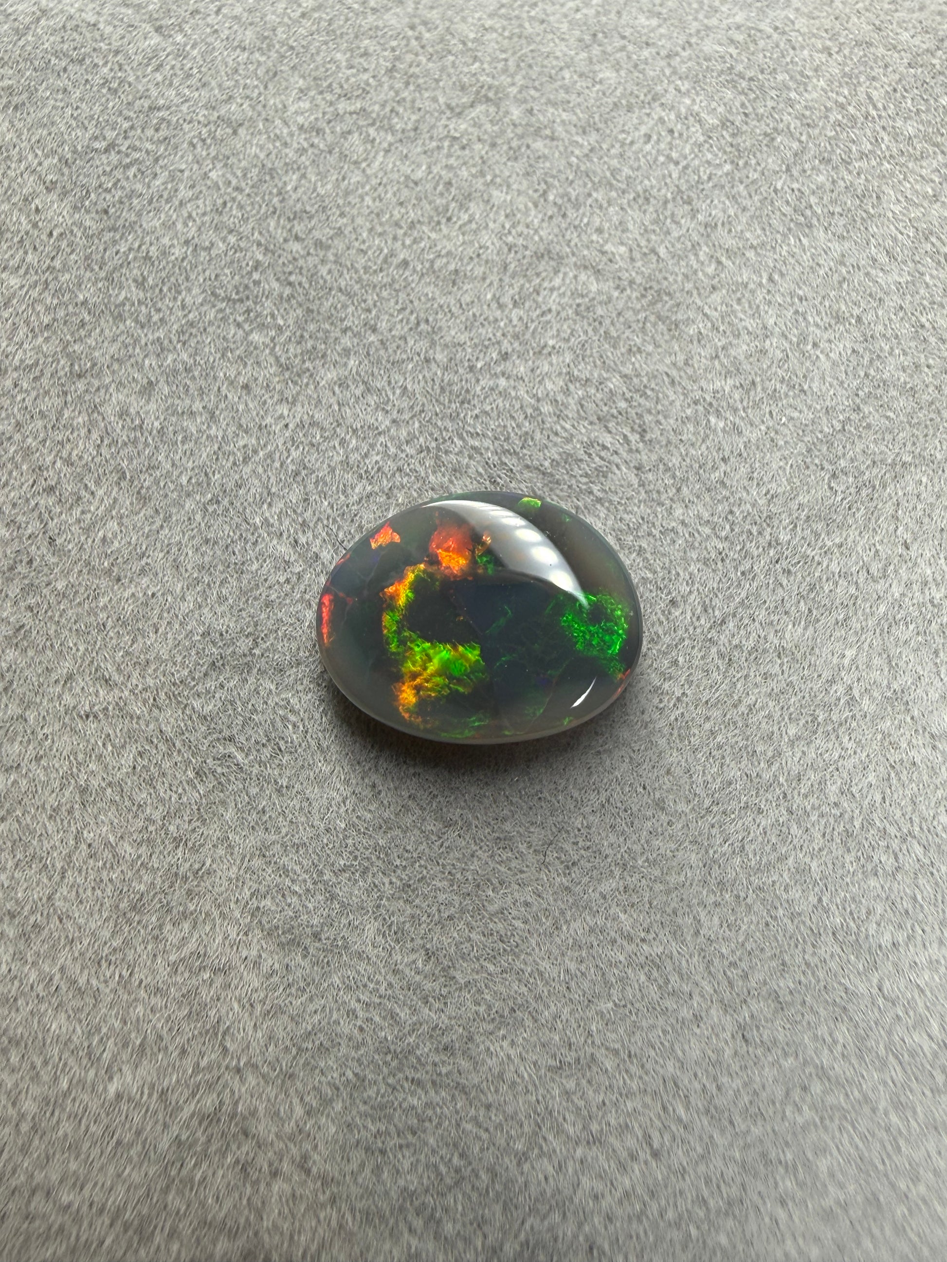Lightning Ridge Dark Opal 1,8 ct in Freiform mit grünem, rotem und orangem Farbspiel.
